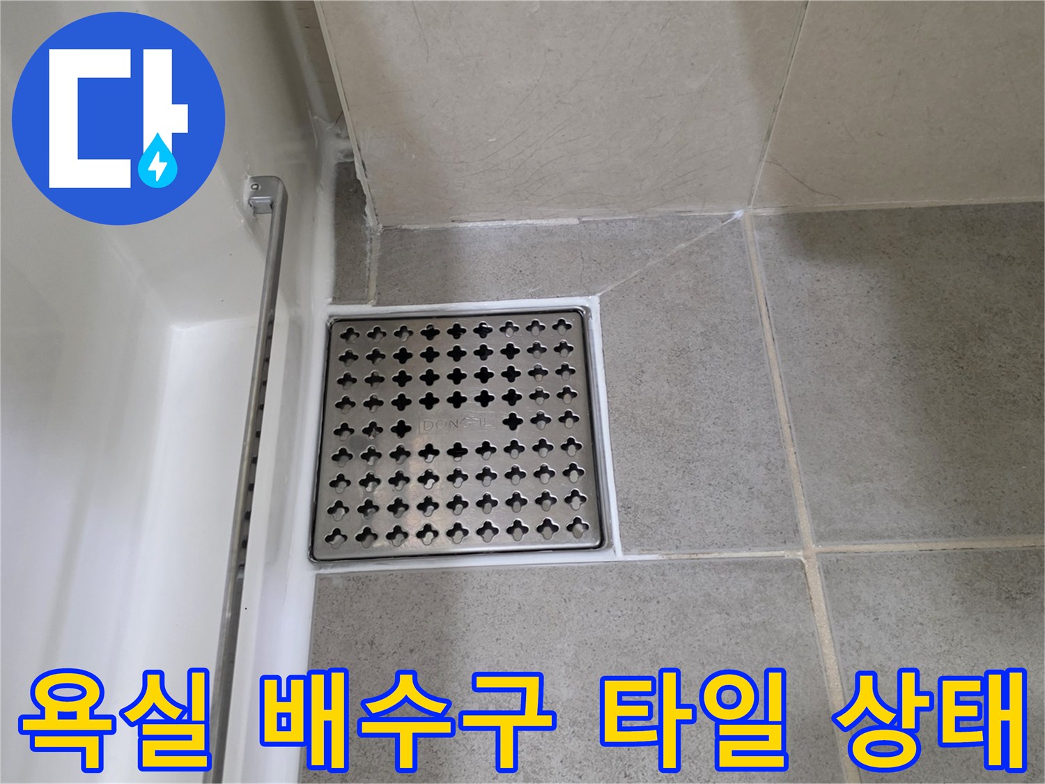 회색 바닥 타일과 금속 재질의 배수구 유가 연결 부위