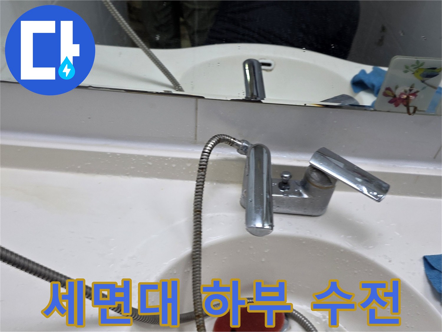 욕실 세면대 아래쪽 샤워 호스 및 수전 모습