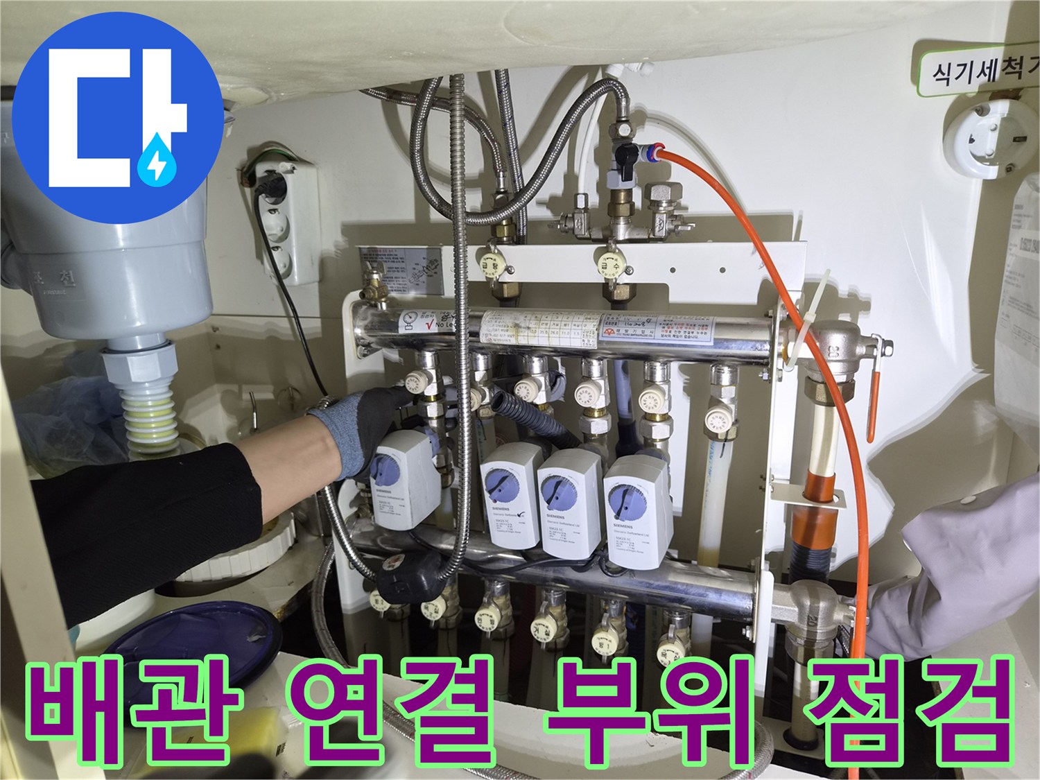 싱크대 아래-분배기와 배관들의 누수 여부 확인 중