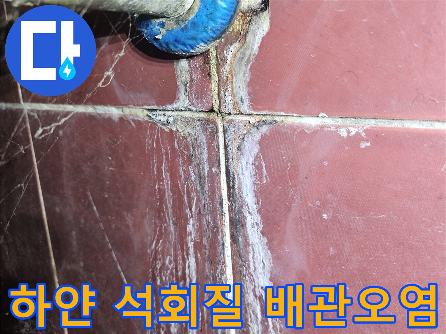 파란색 마감재와 붉은 타일 사이의 하얀색 물때 흔적