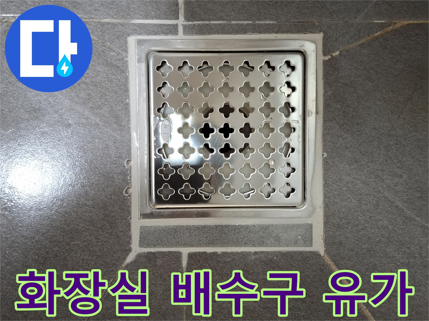 회색 타일 바닥의 스테인리스 배수구 캡 모습