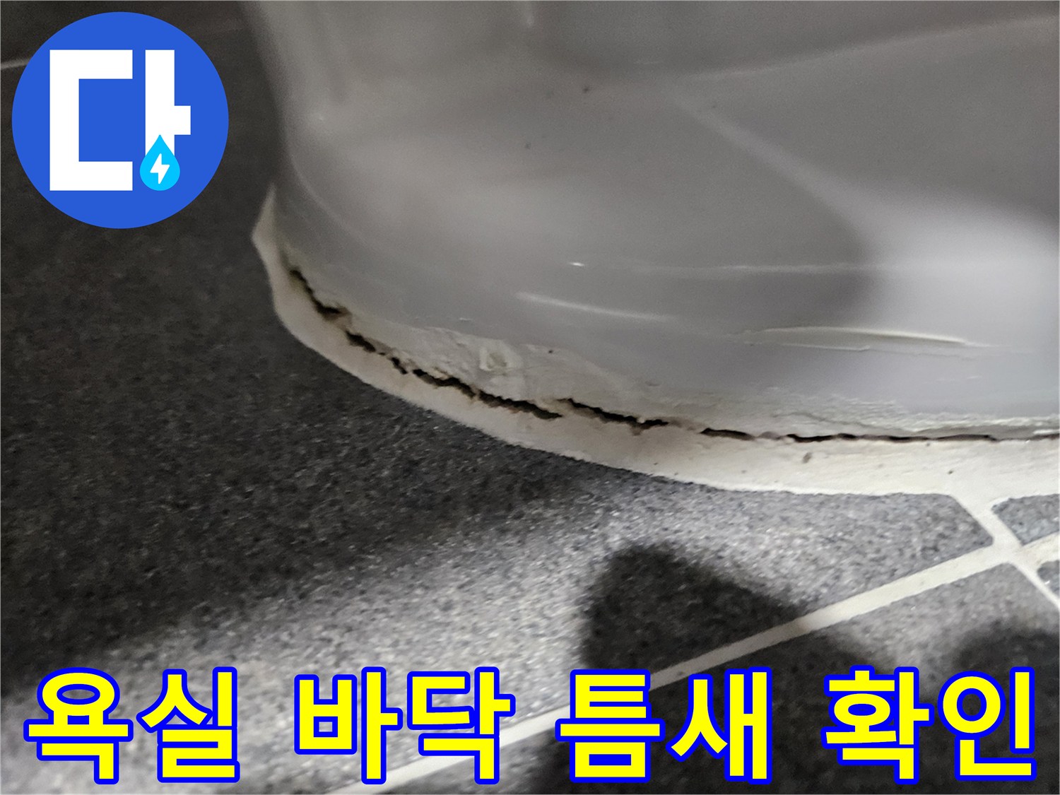 양변기 하단부의 갈라진 백색 마감재 부위