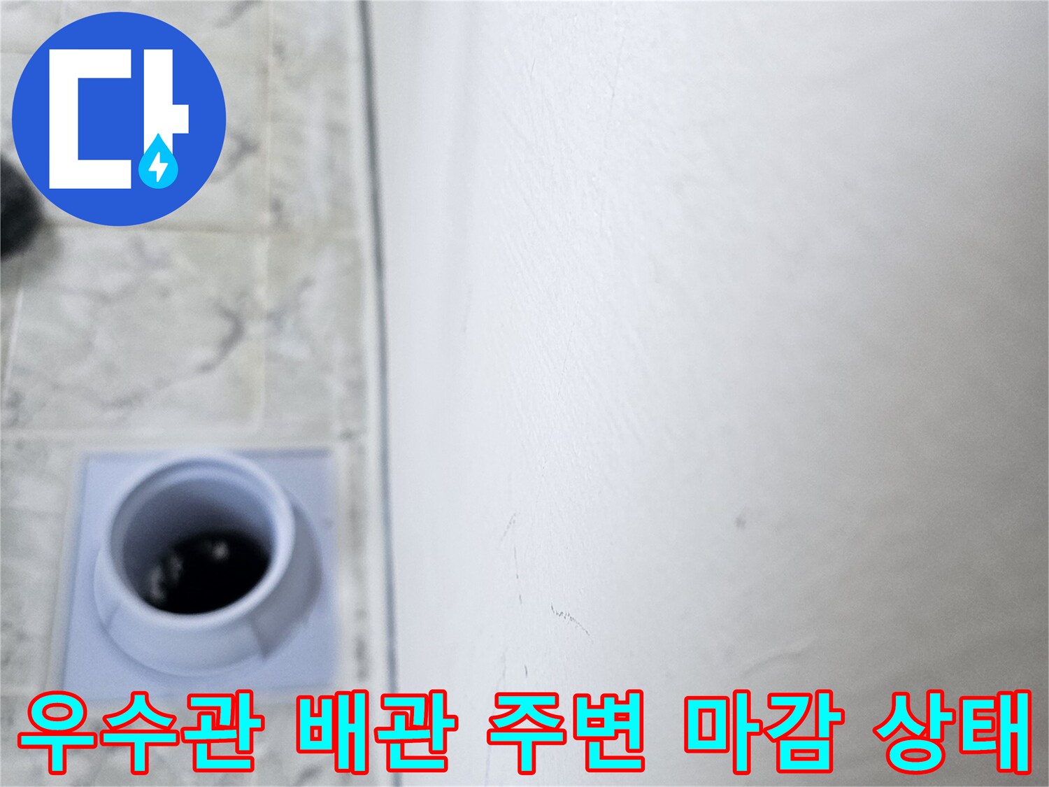 하얀색 배관 입구와 타일 바닥의 접합 부위 사진