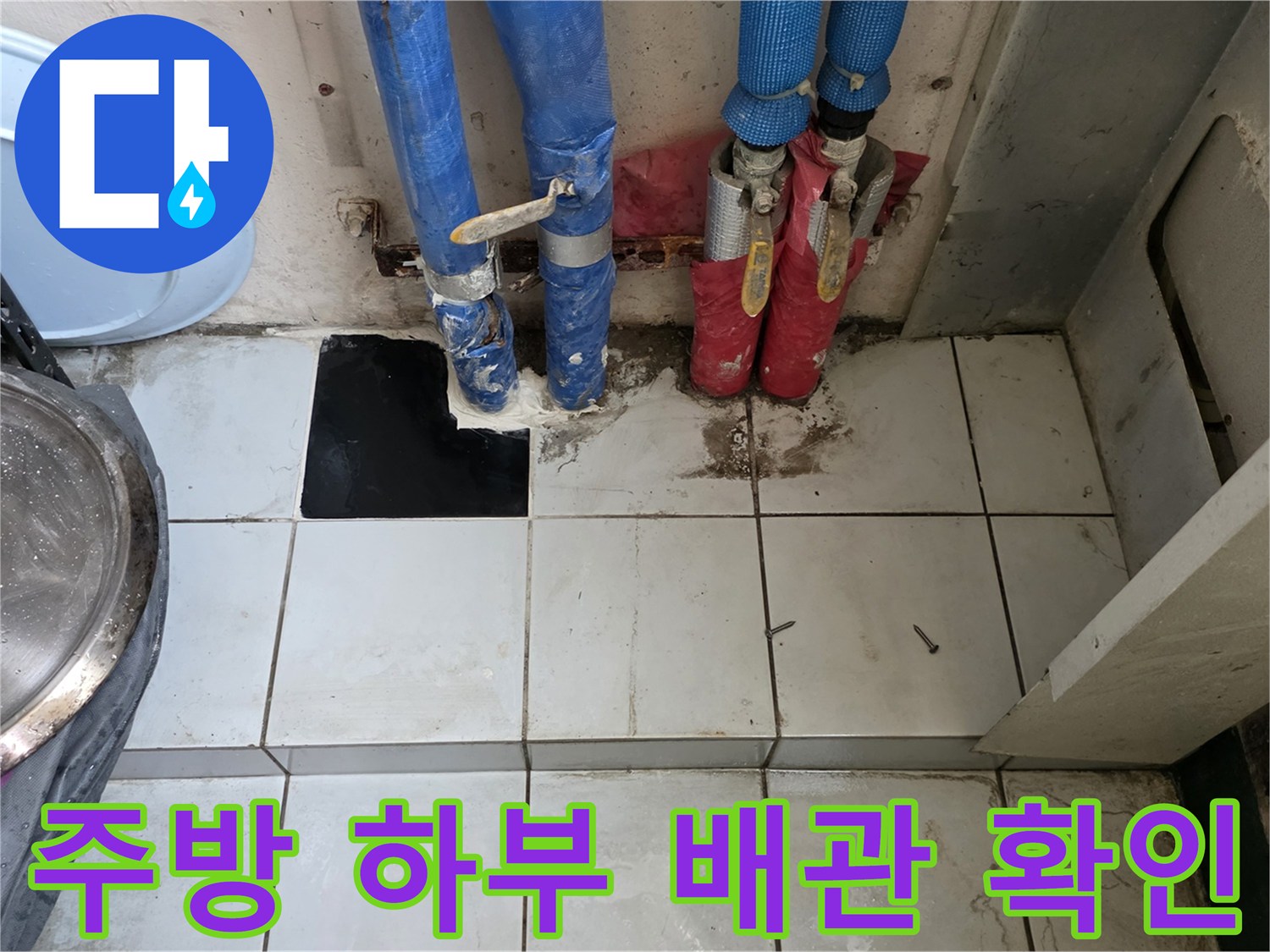 싱크대 아래 타일 바닥의 배관 연결 상태 사진