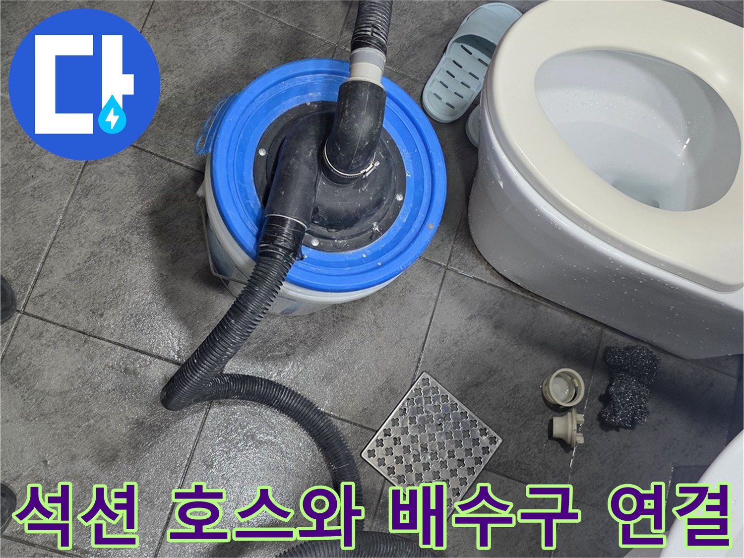 화장실 타일 바닥 배수구에 연결된 석션 장비의 모습