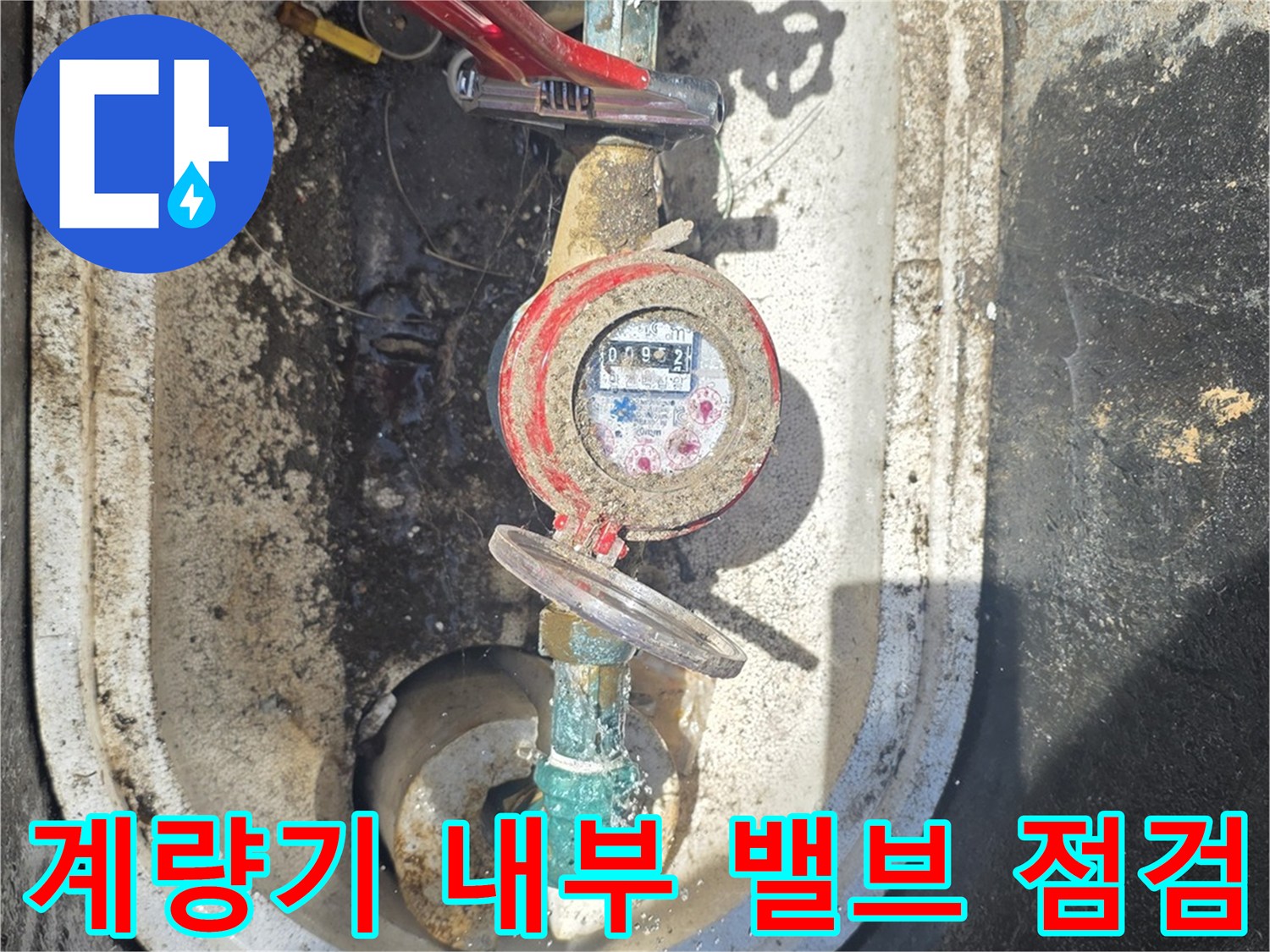 붉은색 밸브와 함께 보이는 수도 계량기 장치