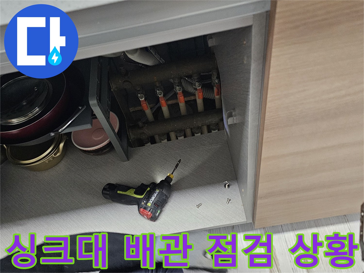 작업자가-싱크대-하단-배관을-살피는-모습