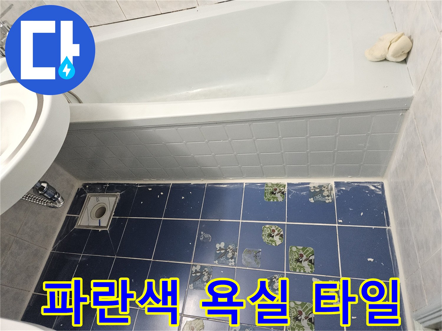 욕실 바닥의 파란색 타일 및 배수구 시설물