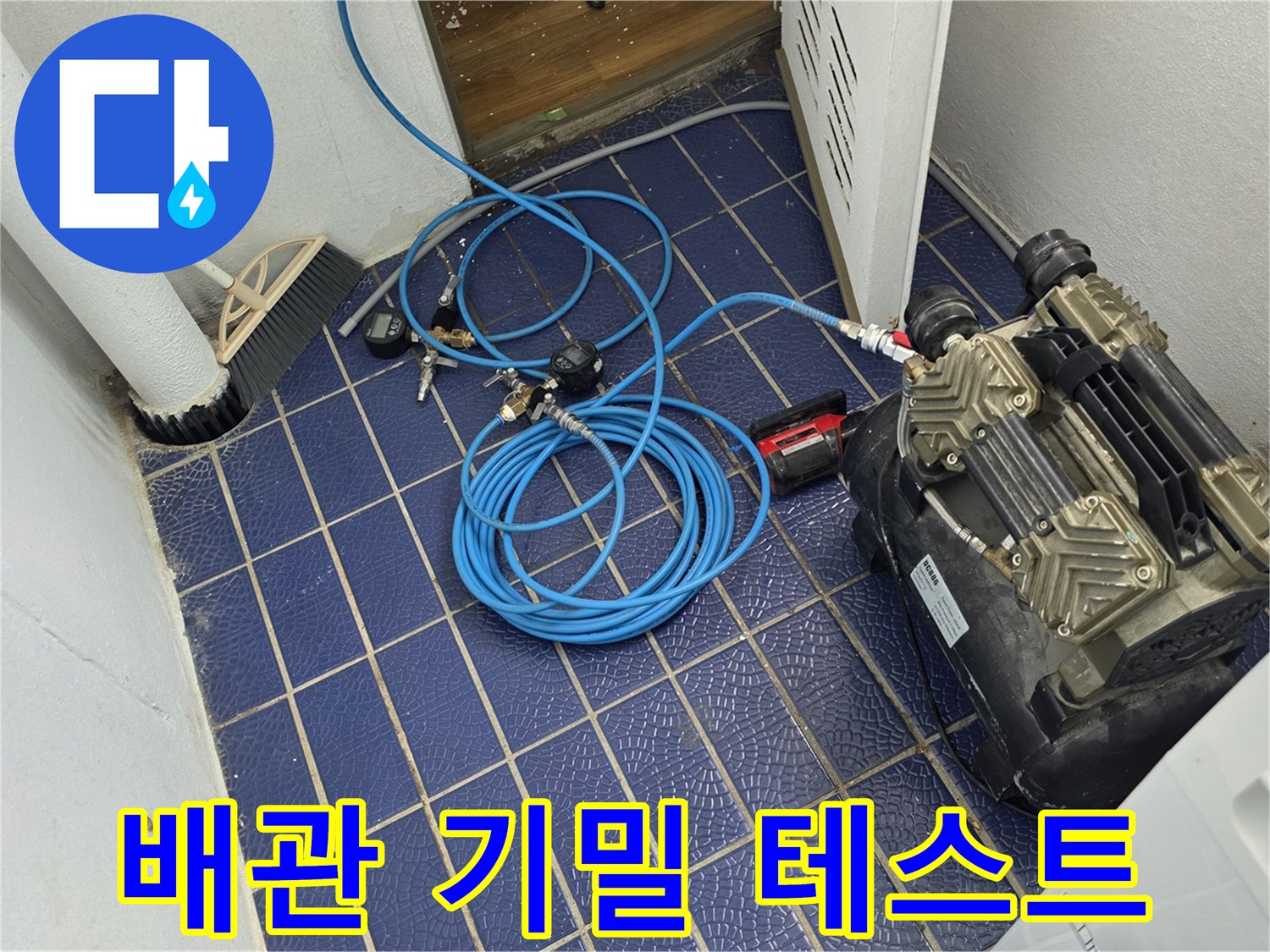 파란색 호스가 연결된 콤프레셔 장비와 타일 바닥 현장