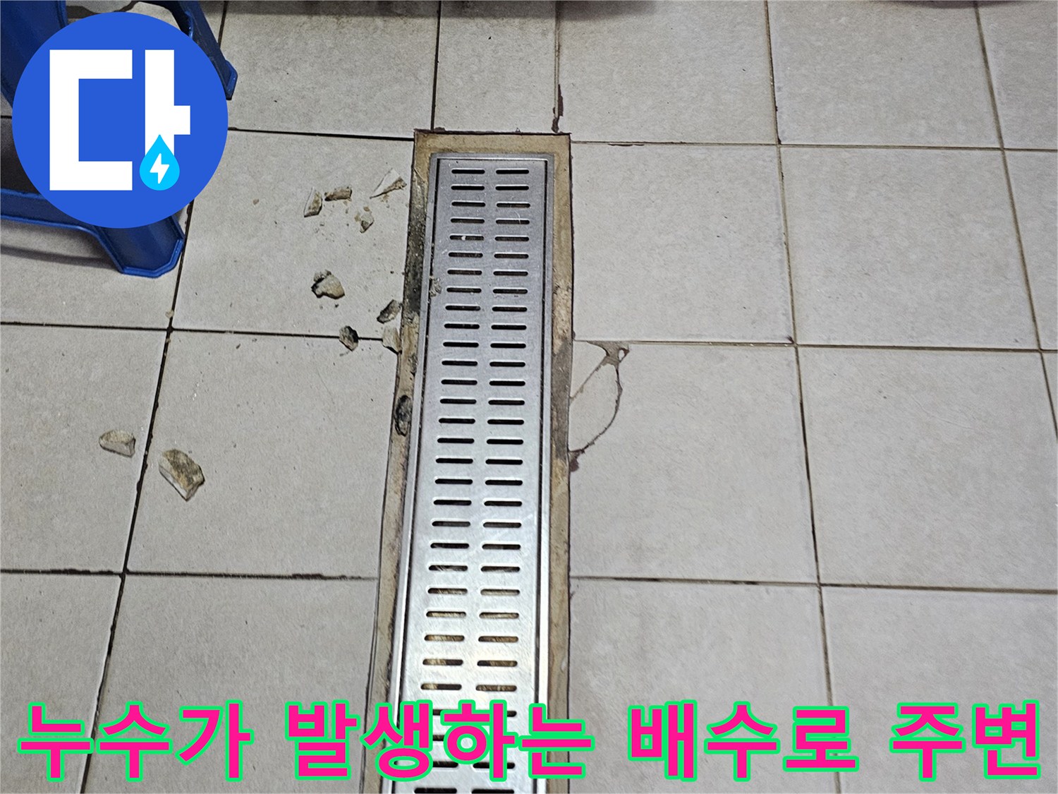 금이 간 타일과 금속 트렌치 덮개의 모습
