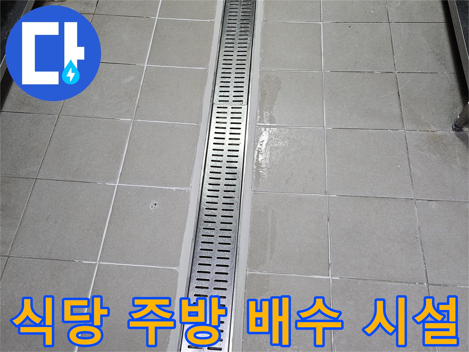 스테인리스 재질의 긴 배수 트렌치와 타일 바닥