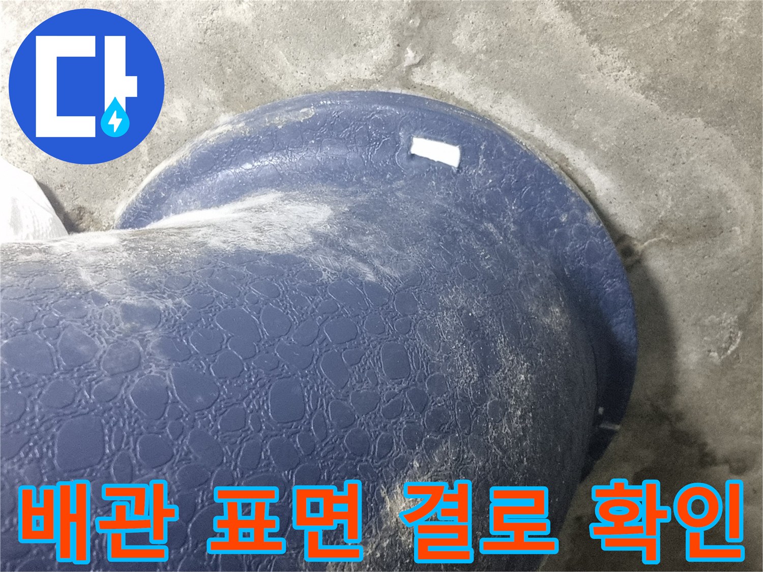 축축하게 젖어 있는 파란색 오수관의 모습입니다.