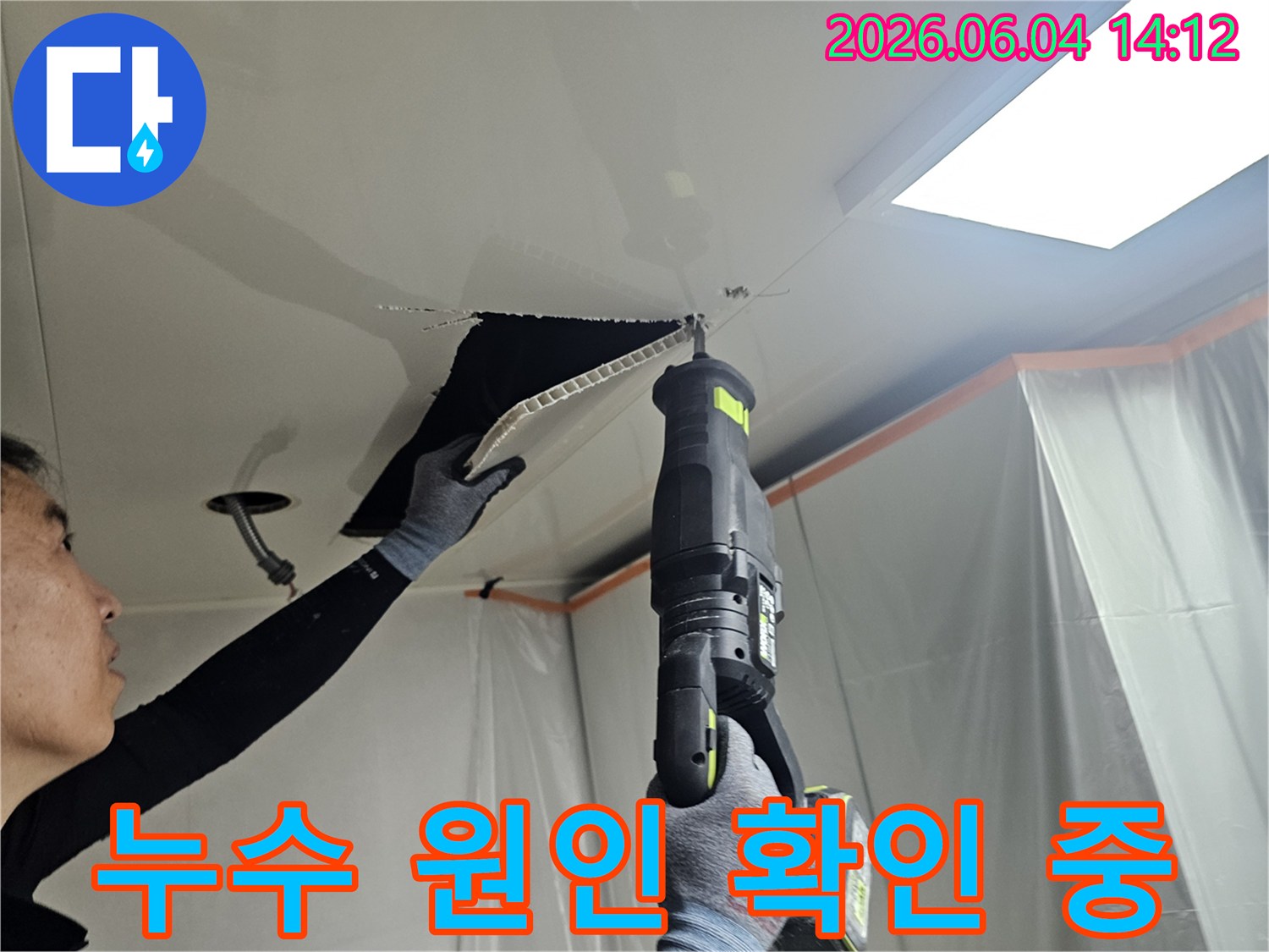 누수-공사-중-천장-패널을-정밀하게-절단하는-작업자의-모습