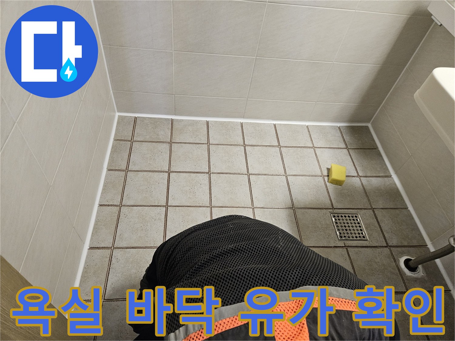 배수구 주변 타일 마감 상태 확인 중