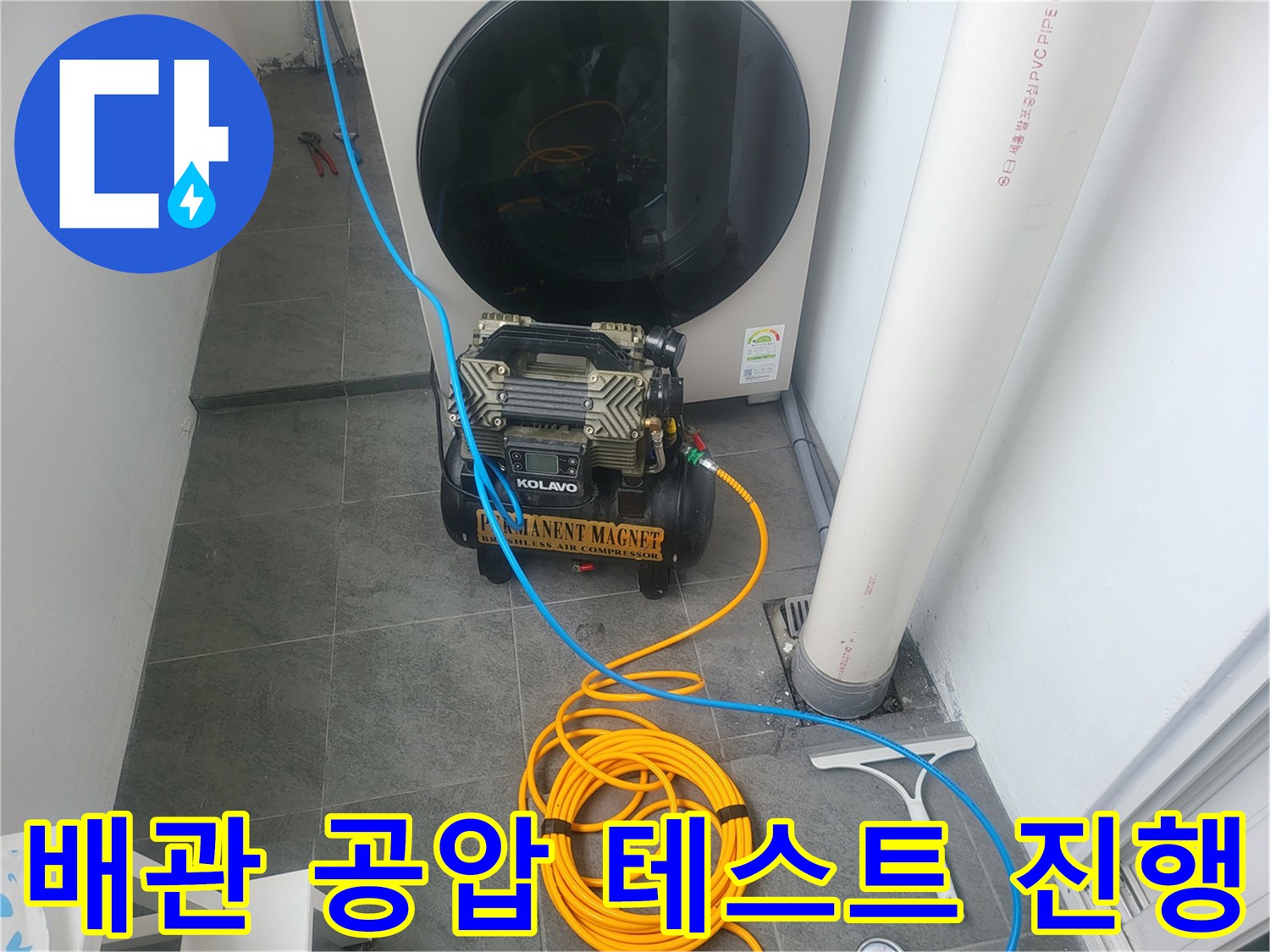 세탁기 뒤쪽 좁은 공간에 배치된 배관 압력 측정용 장비와 호스