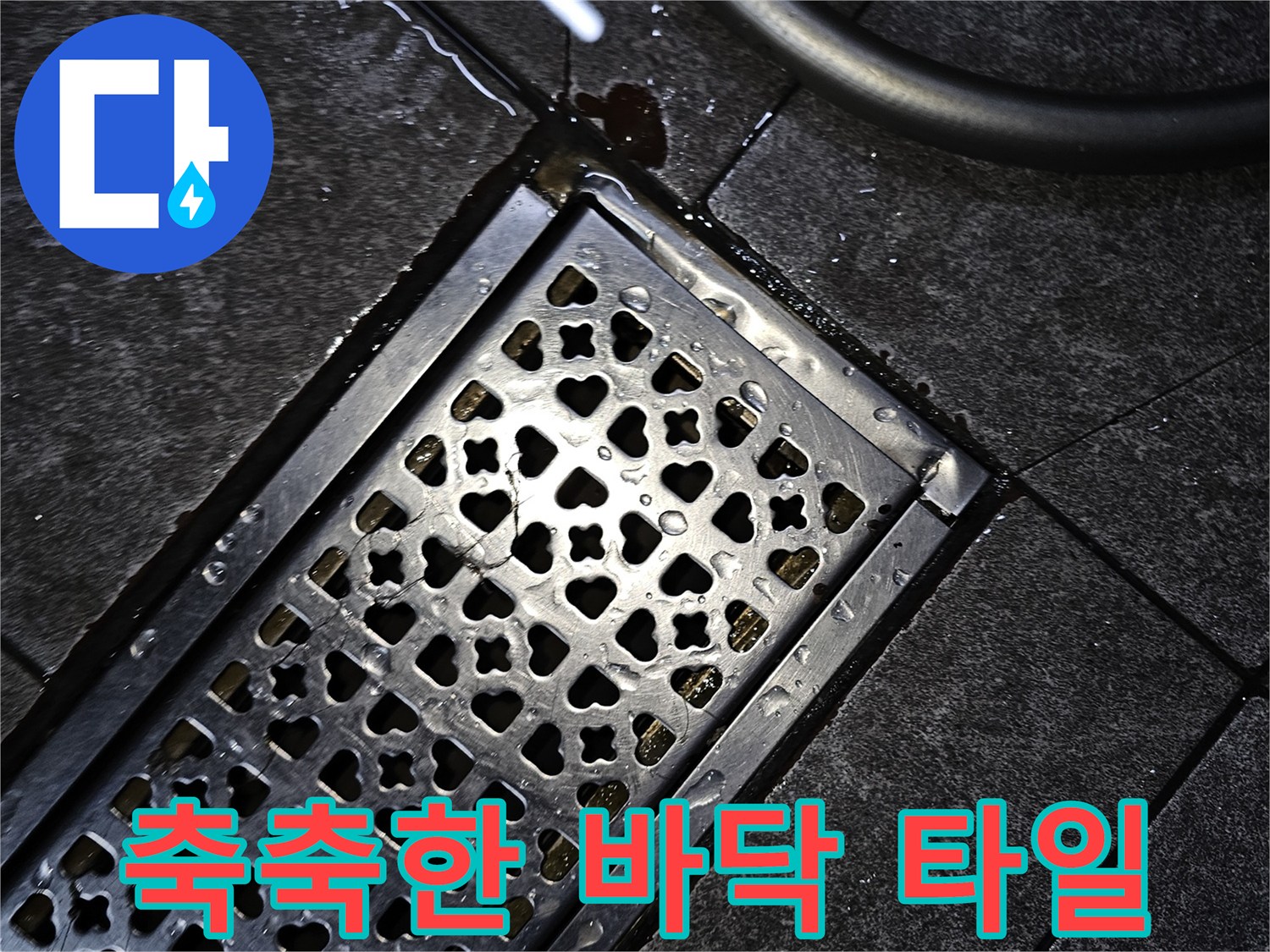 금속 격자 배수구와 물기가 맺힌 어두운 타일