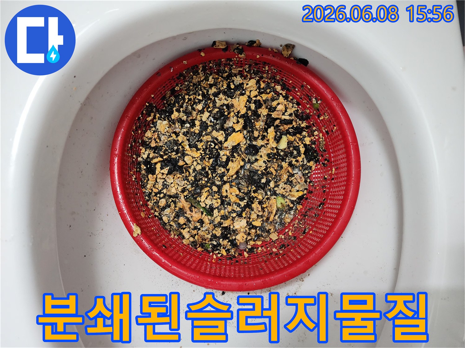 빨간색 채에 담긴-잘게 부서진 기름 슬러지 덩어리