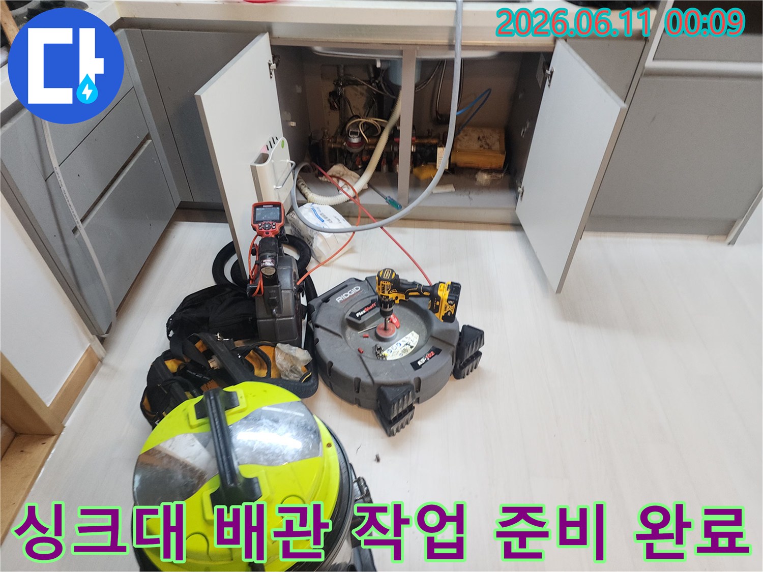 싱크대 하부장 내부의 배관 점검 및 장비 배치 모습