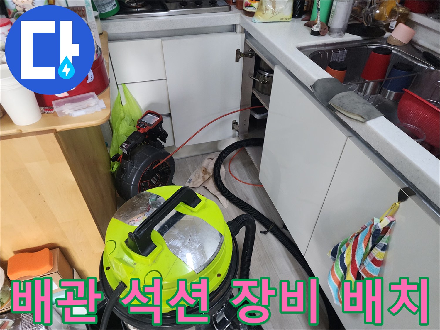 싱크대 하단 배수구의 막힌 부분을 해결하기 위한 석션기 작동 모습