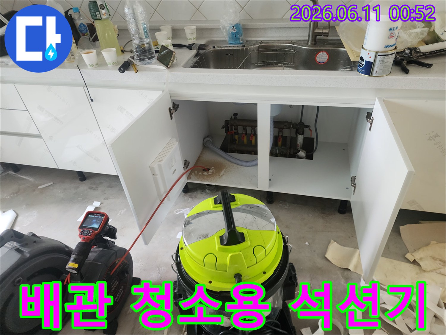 싱크대 아래쪽 작업 공간-막힌 배관을 뚫기 위한 전문 장비 세팅