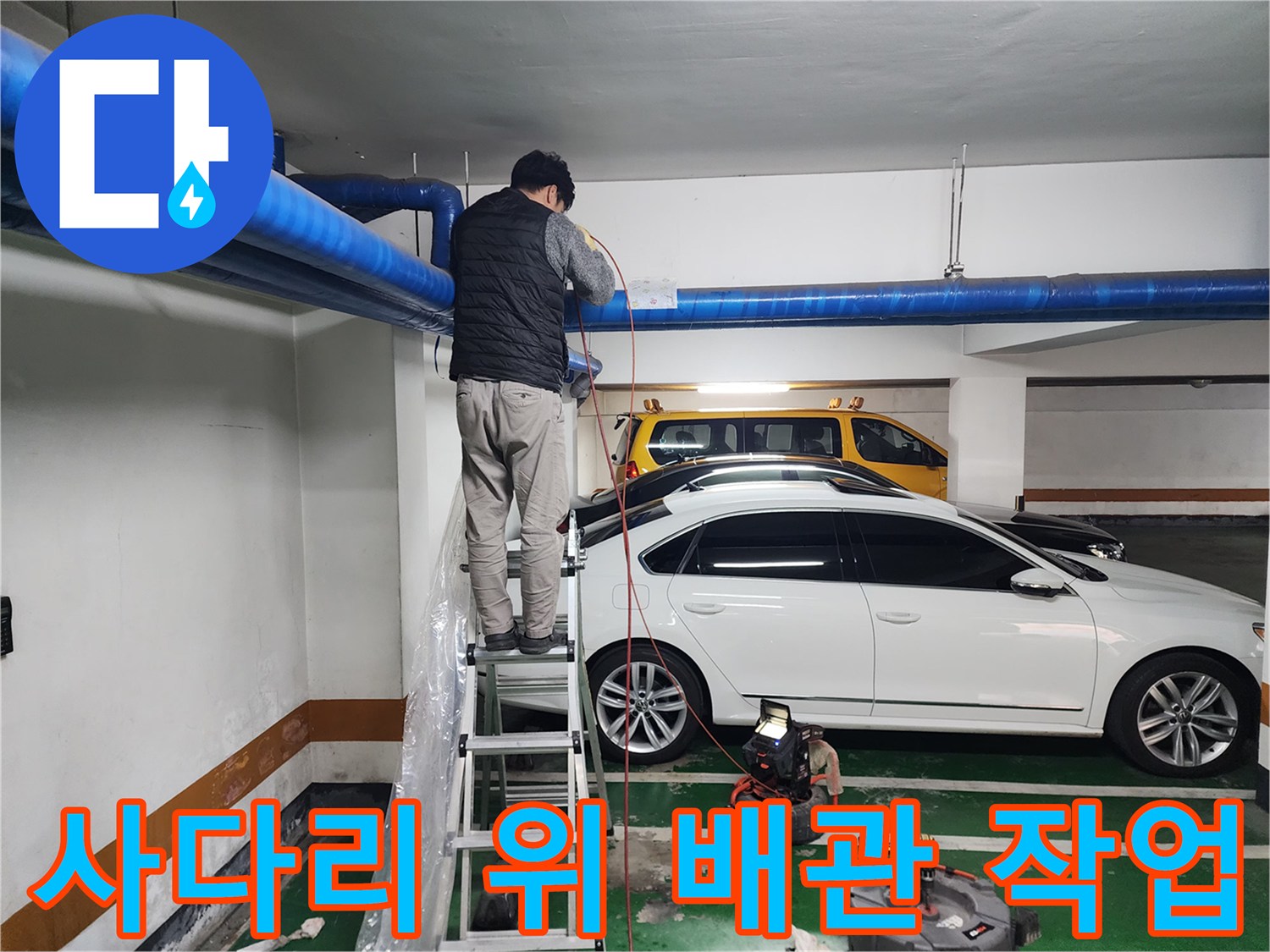 지하주차장 천장 배관을 점검하기 위해 사다리에 올라간 작업자 모습