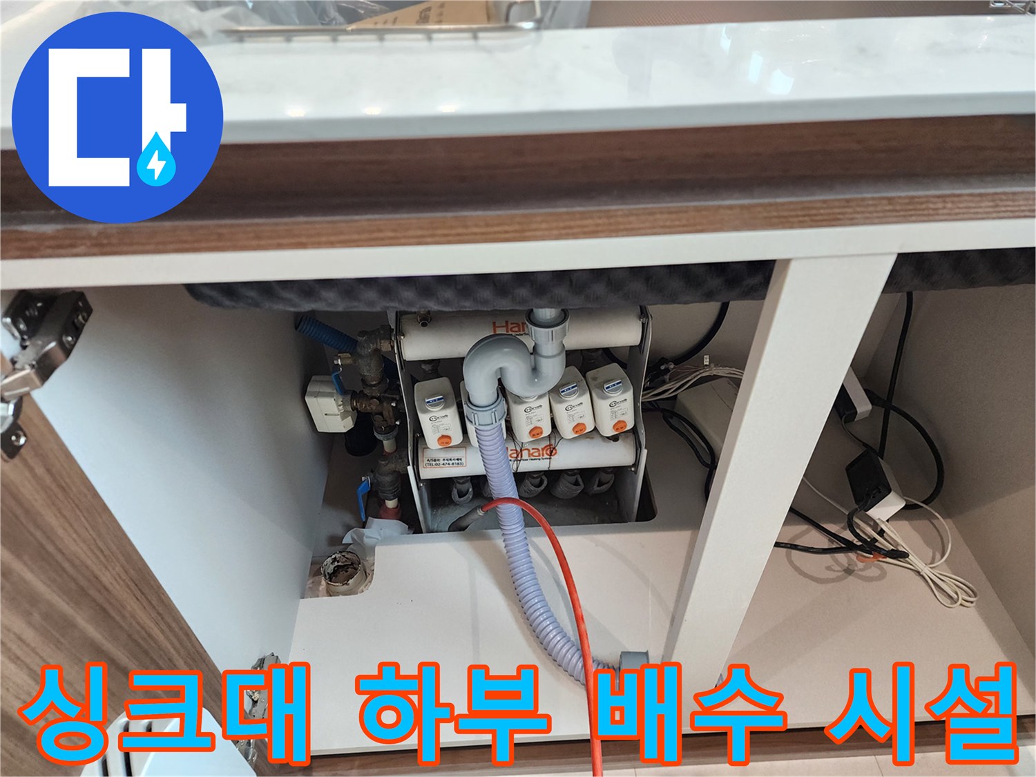 싱크대 아래쪽-복잡하게 연결된 배수 호스와 부품들