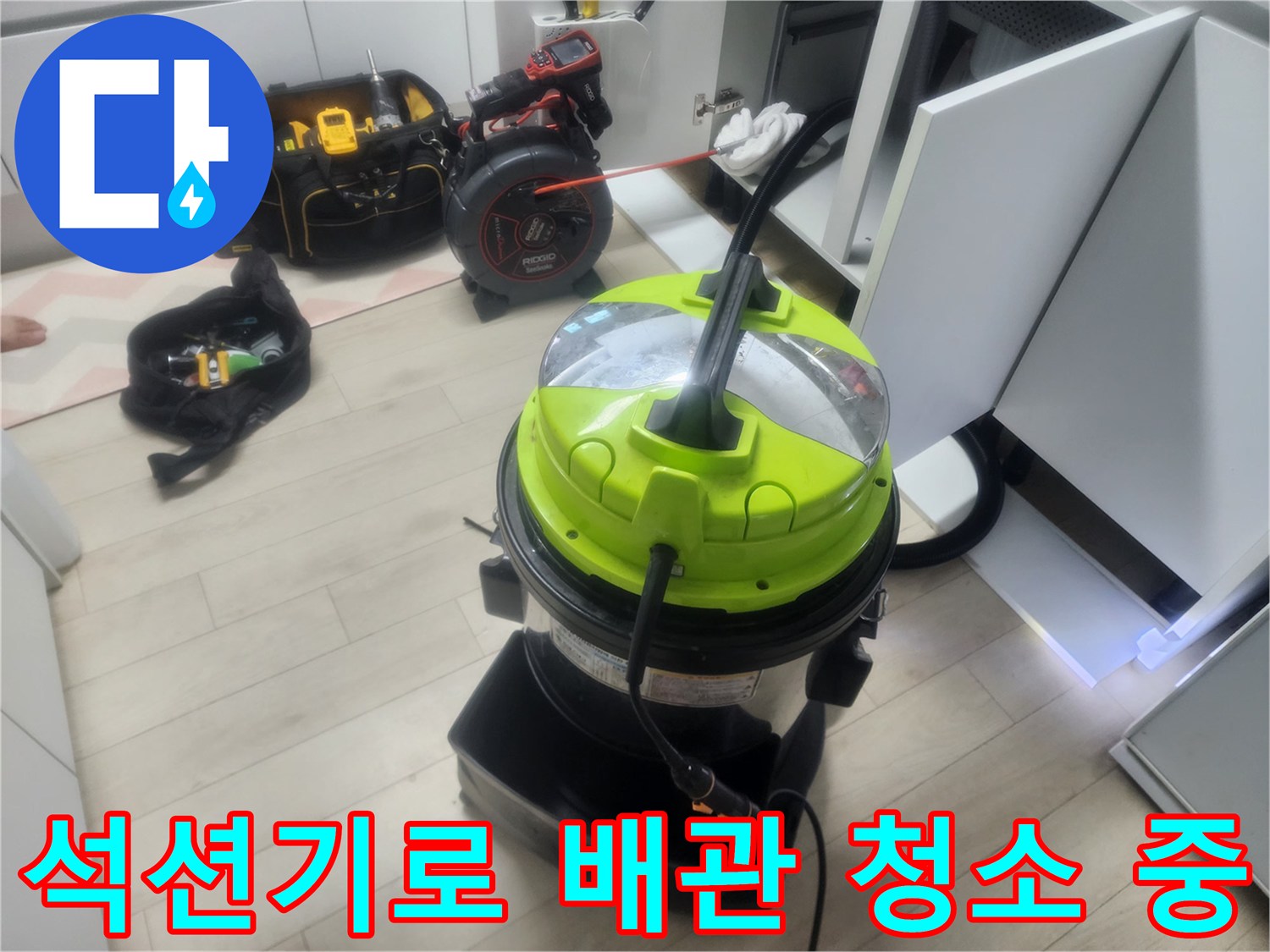 싱크대 밑 하부장 공간에서 작업 중인 석션기와 전동 장비