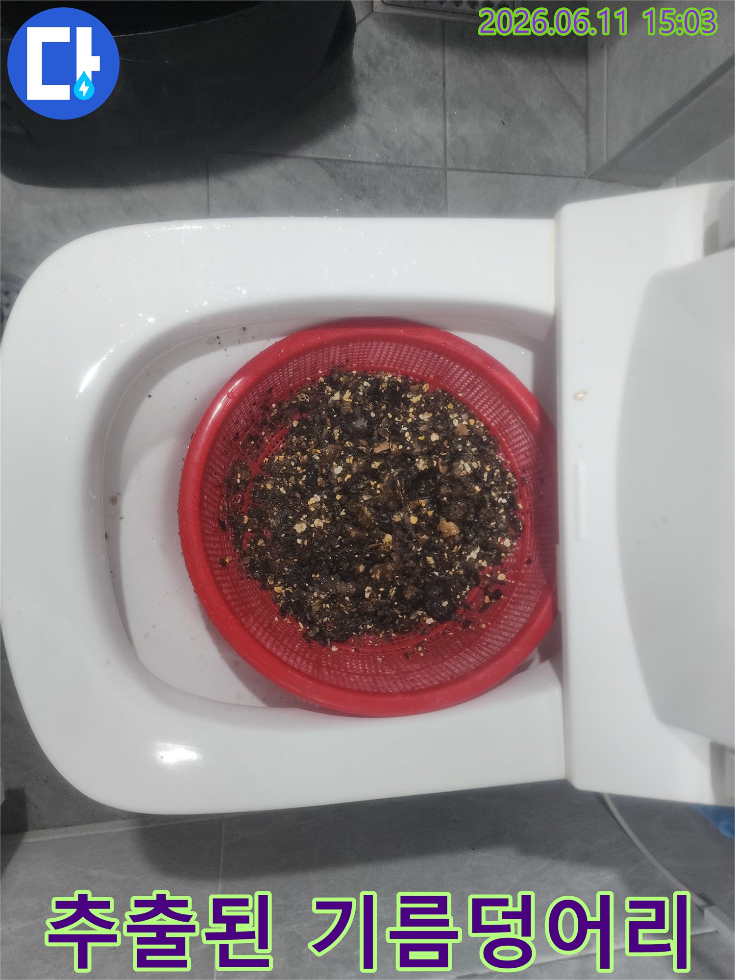 채반에 걸러진 검은색 기름 슬러지와 이물질 찌꺼기