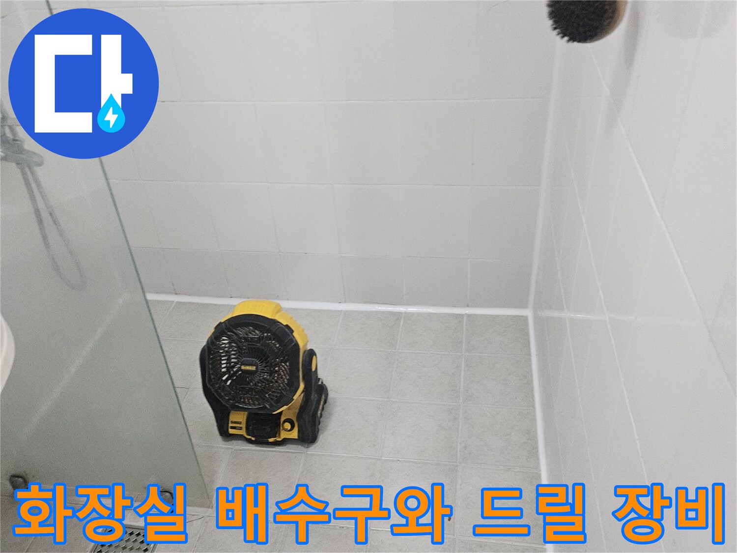하얀 타일 바닥의 배수구와 작업용 전동 드릴