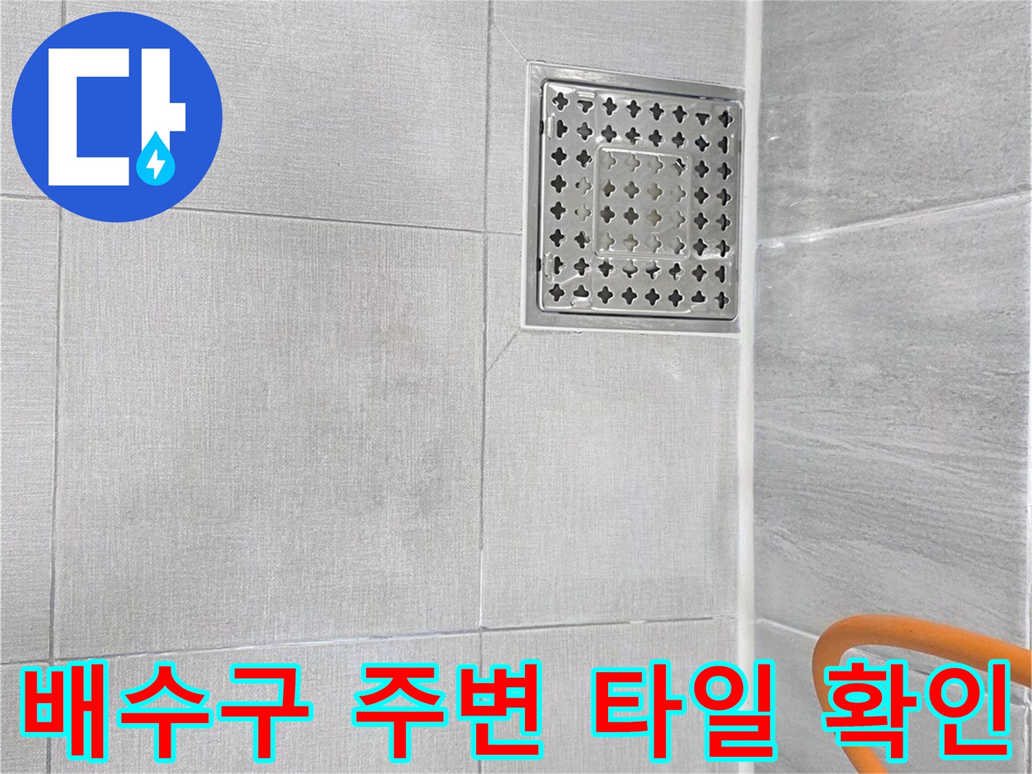 금속 배수구 덮개와 인접한 욕실 바닥 타일
