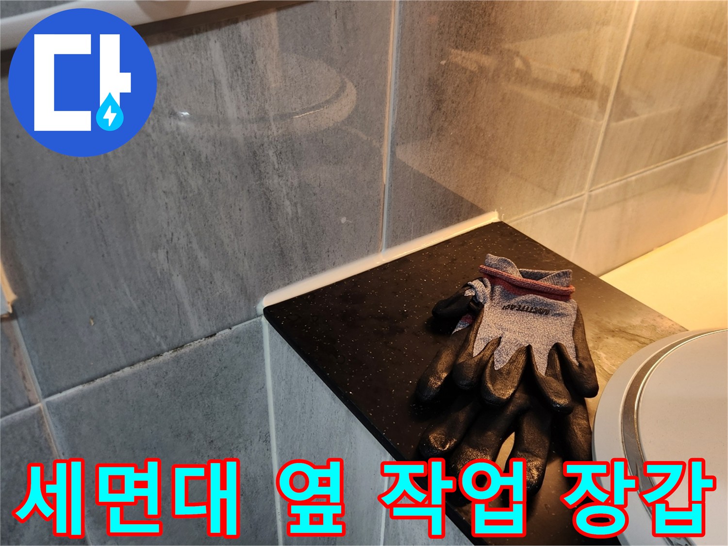 타일 벽면 앞 세면대 주변의 작업용 장갑