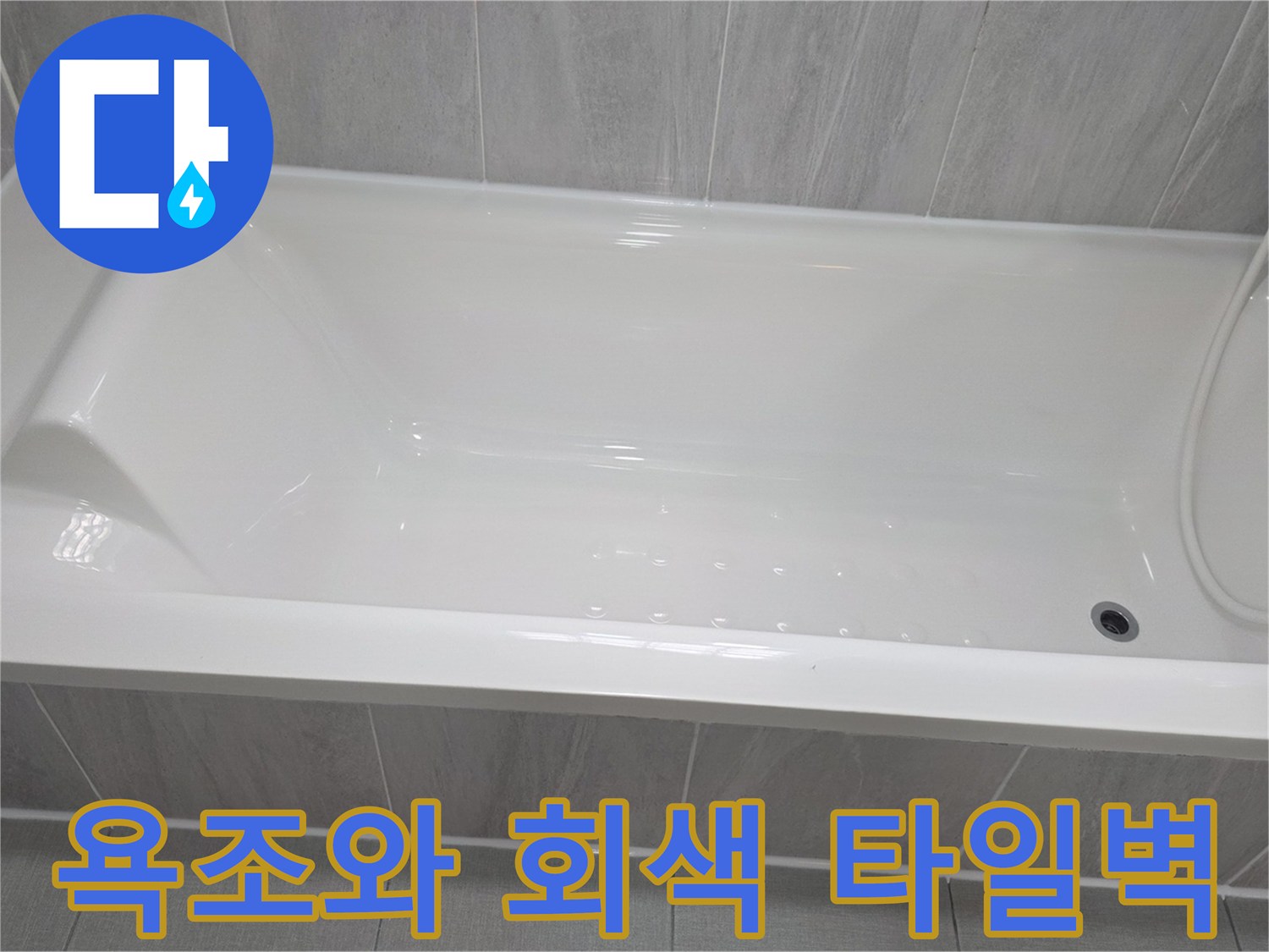회색 타일로 마감된 욕실 벽면과 욕조