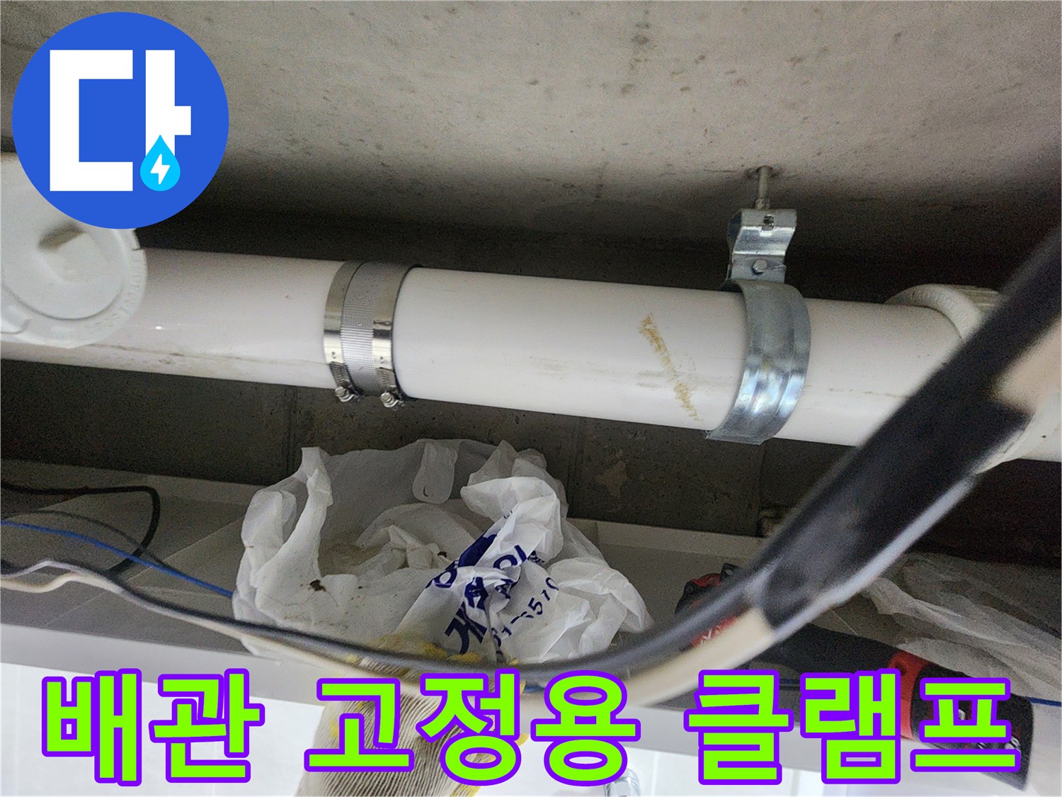 하얀색-PVC-배관과-금속-고정-클램프-근접-사진