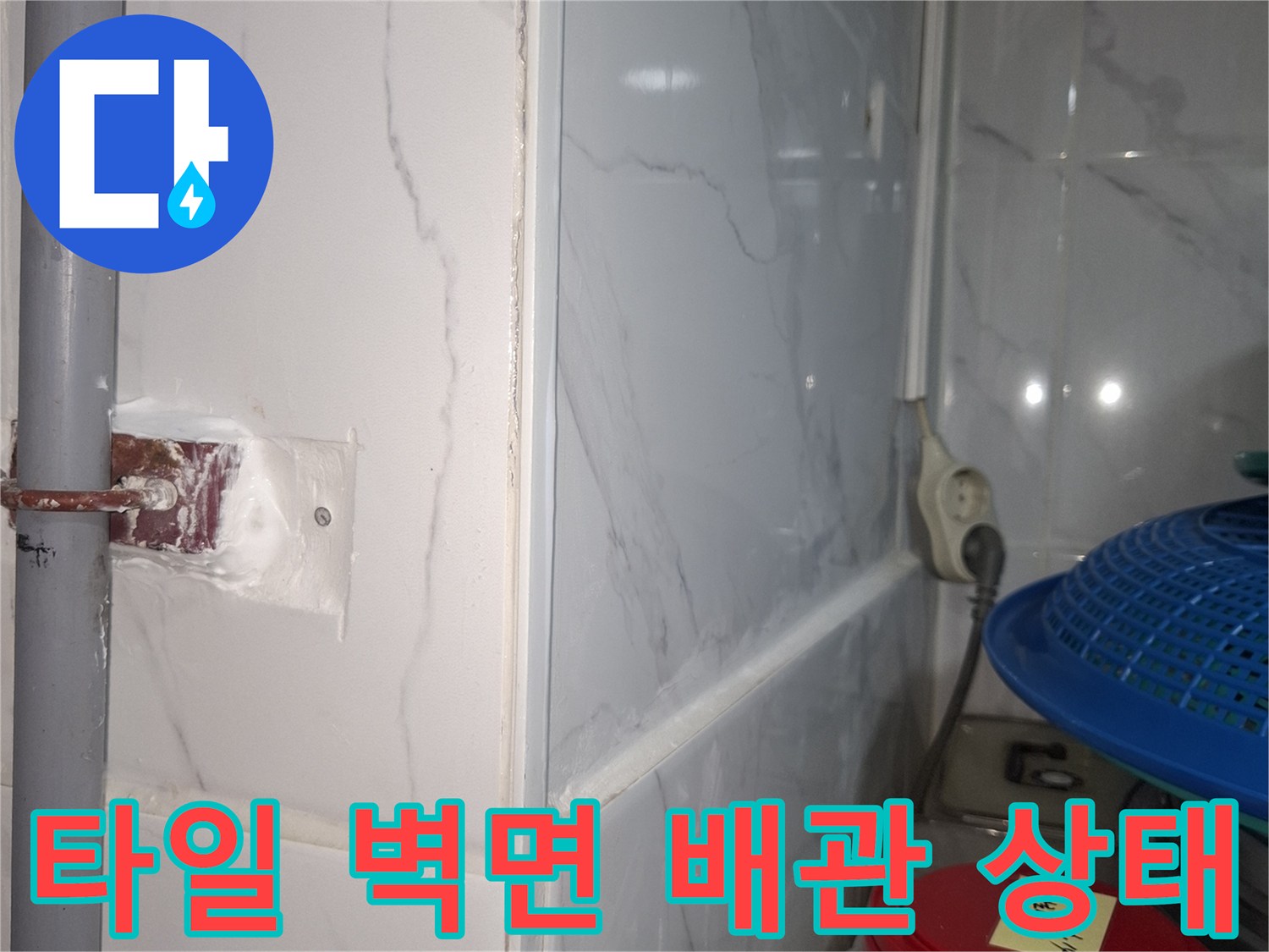 하얀 타일과 회색 배관 사이의 젖은 마감 부위