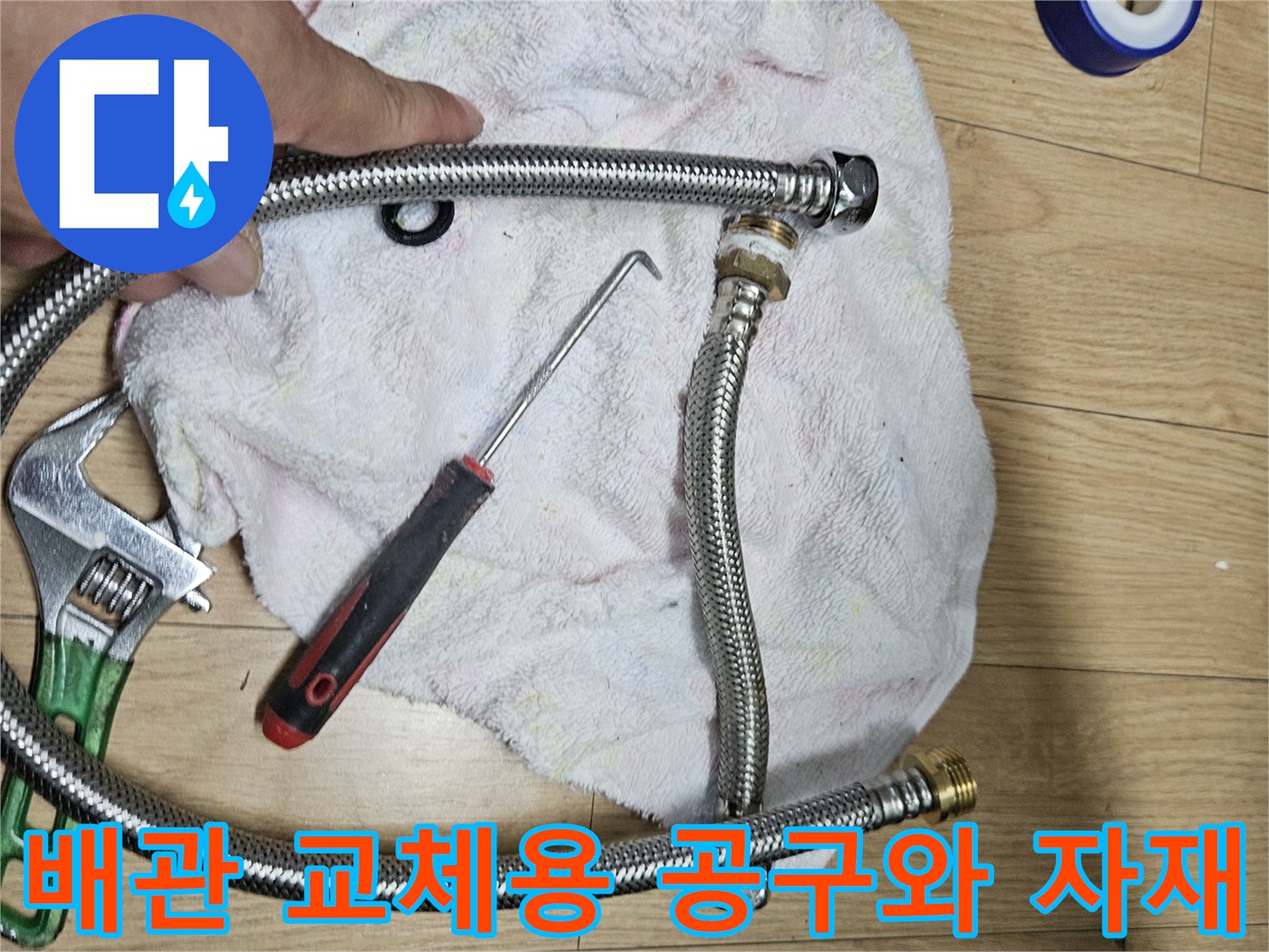 은색 배관 호스와 파란색 테이프 및 수리 도구 모음