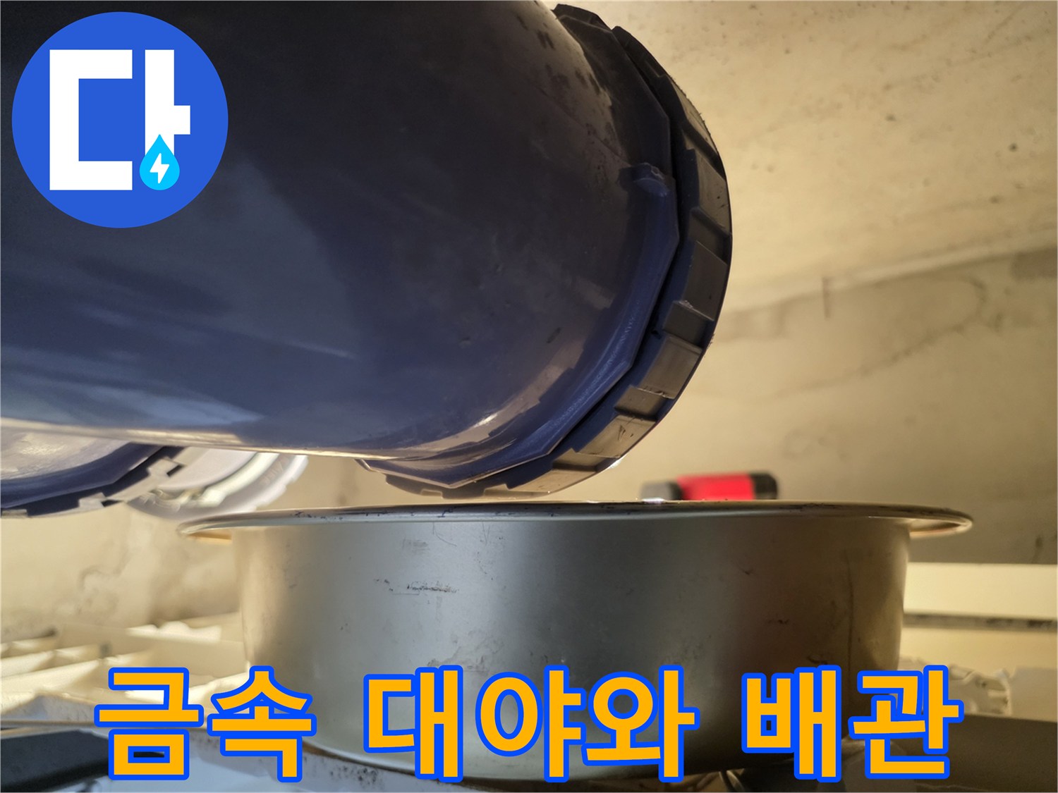 배관 하단에 위치한 금속제 물받이 대야 사진