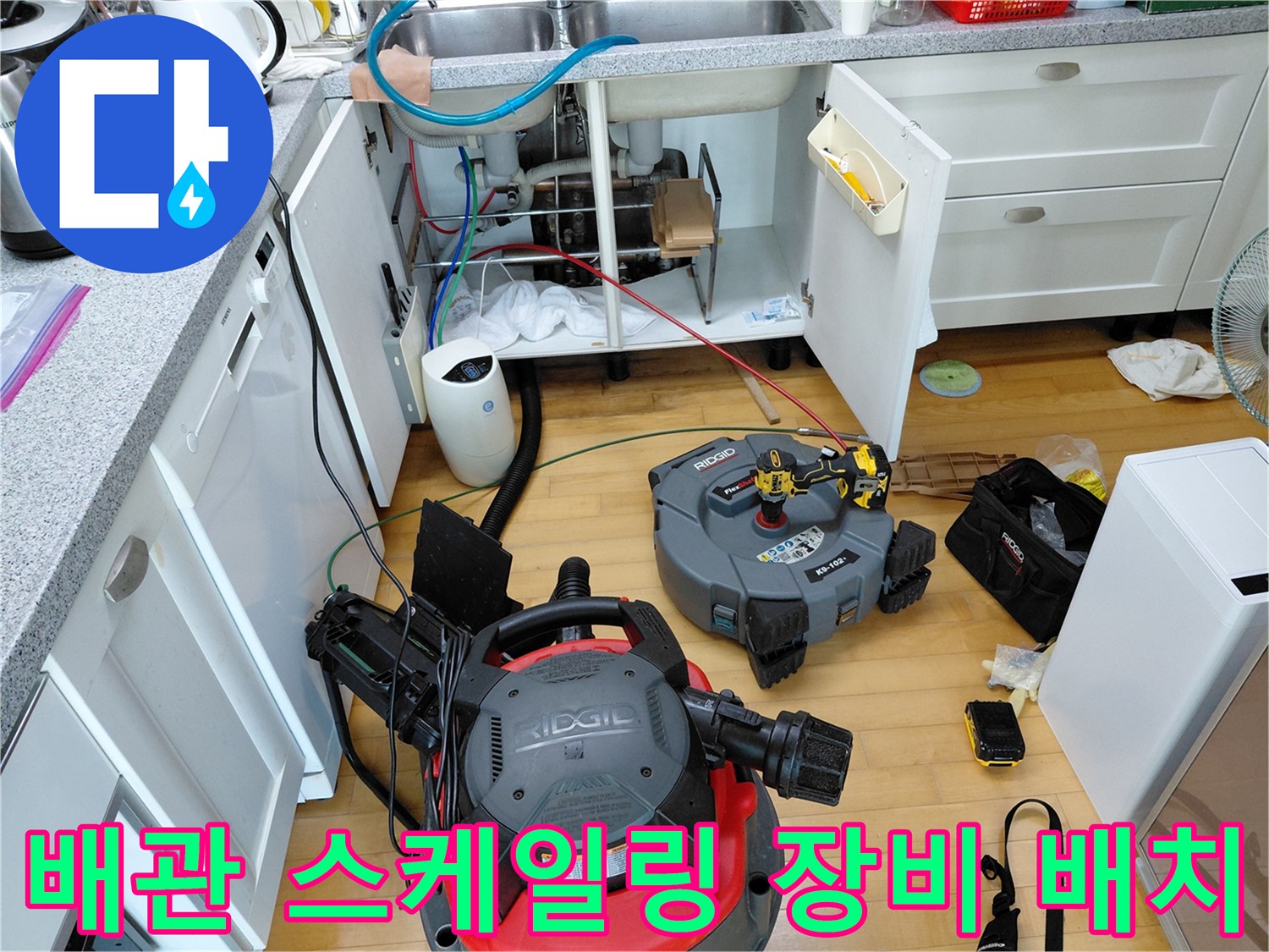 싱크대 밑-배관 세척을 위해 배치된 전문 석션 및 공구들