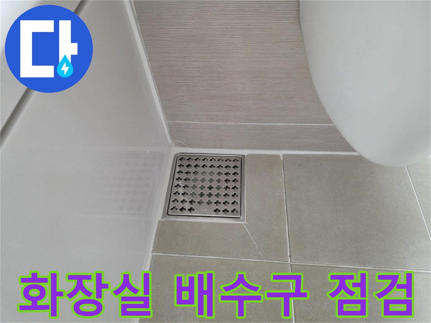 화장실 바닥 타일과 스테인리스 배수구 근접 사진