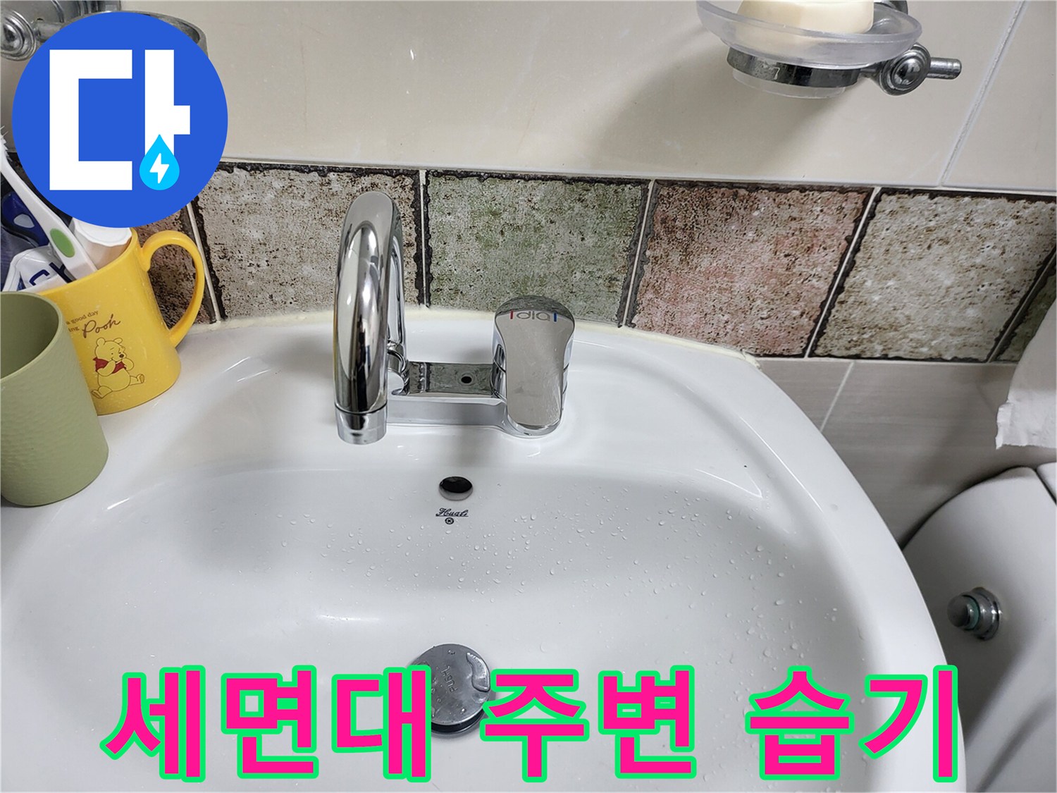물기가 맺힌 세면대와 벽면 타일 모습