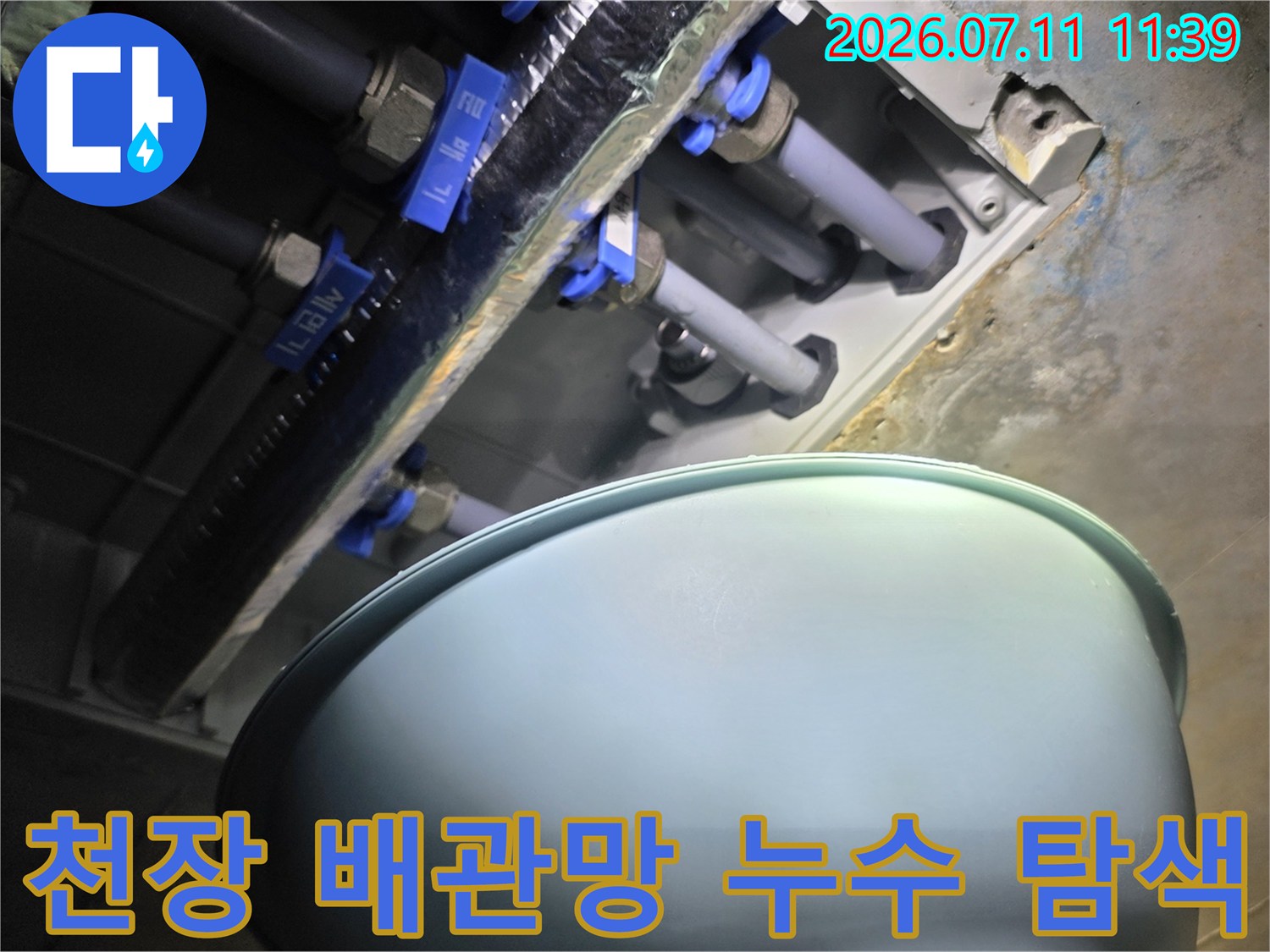 노출된 파란색 부속들과 얽힌 회색 배관의 모습