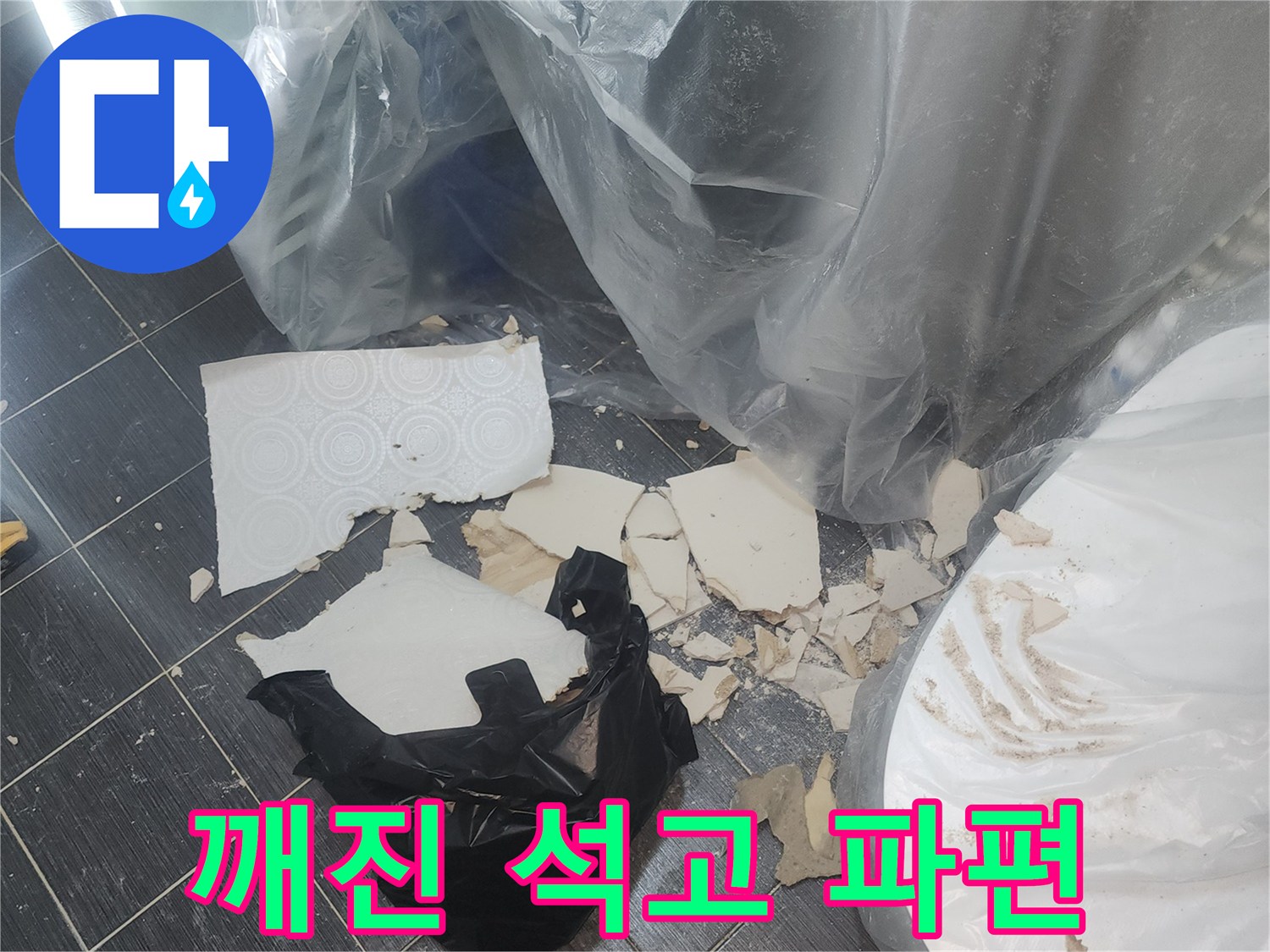바닥 타일 위의 부서진 천장재 잔해물
