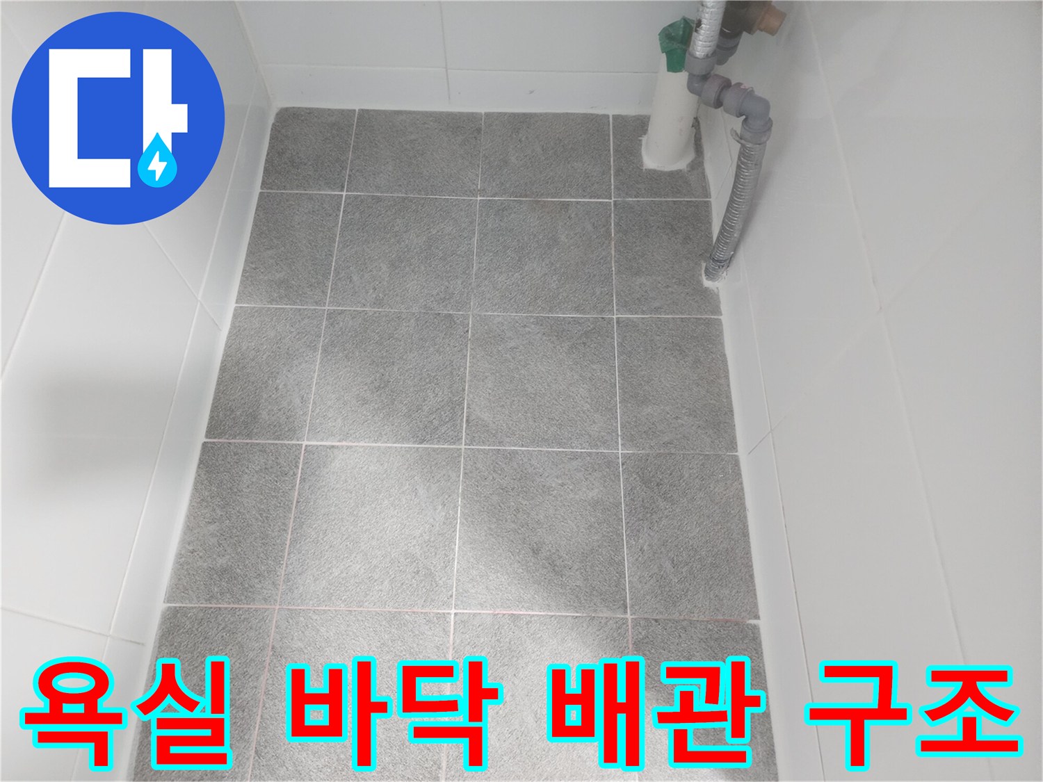 회색 타일 바닥과 상단에 위치한 배관 연결 부위
