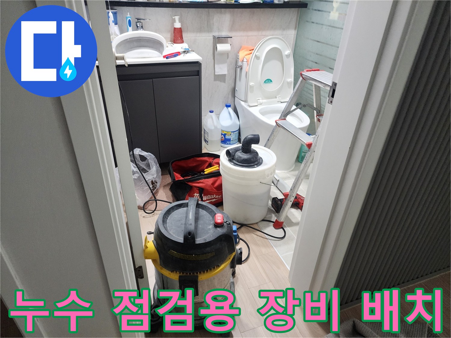 화장실 바닥의 작업용 청소기와 사다리 모습