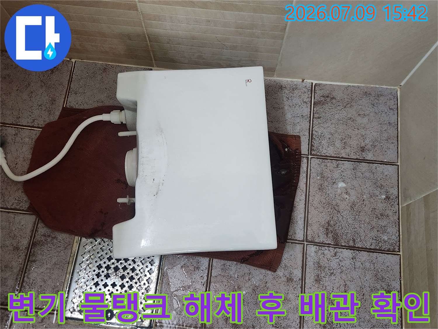 분해된 변기 물탱크와 연결된 수전 호스 부분