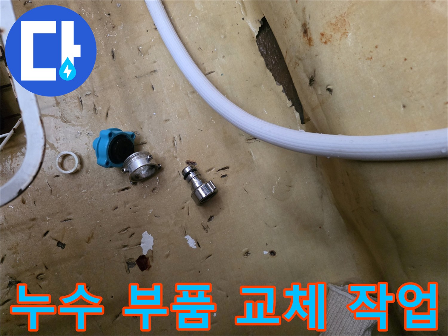 바닥에 놓인 파란색 밸브와 금속 연결 부위