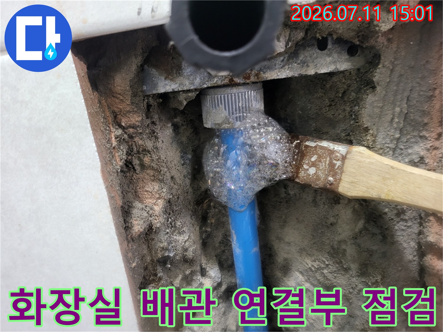 거품을 도포하여 배관 부속의 결함을 확인하는 작업 현장 사진