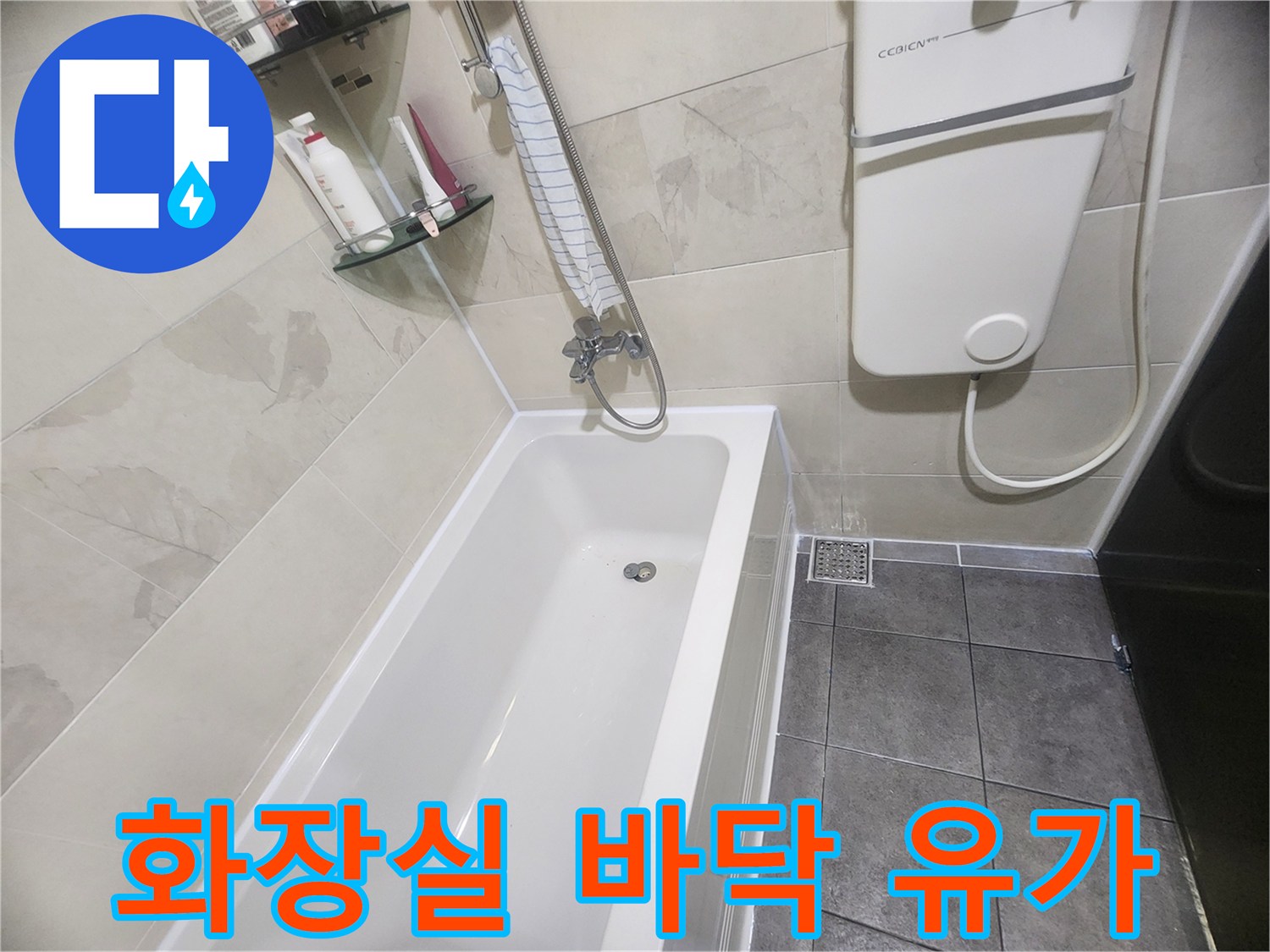 하얀색 욕조와 회색 타일 바닥의 배수구 모습