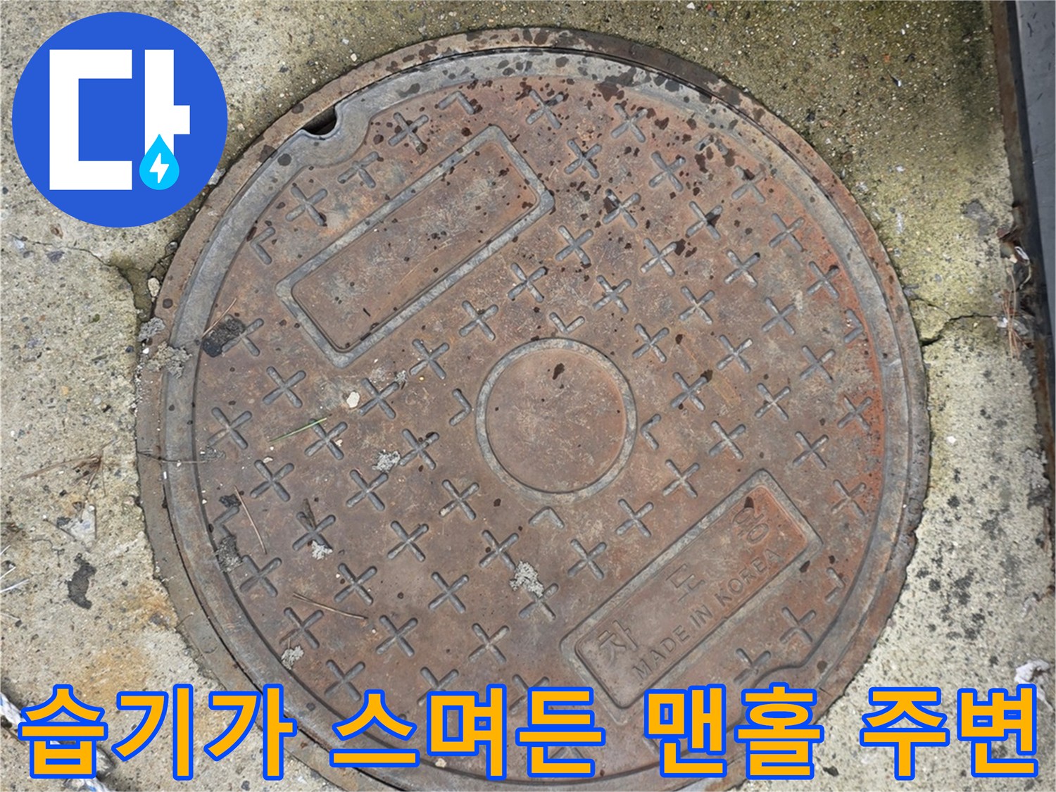젖은 바닥과 철제 맨홀 덮개