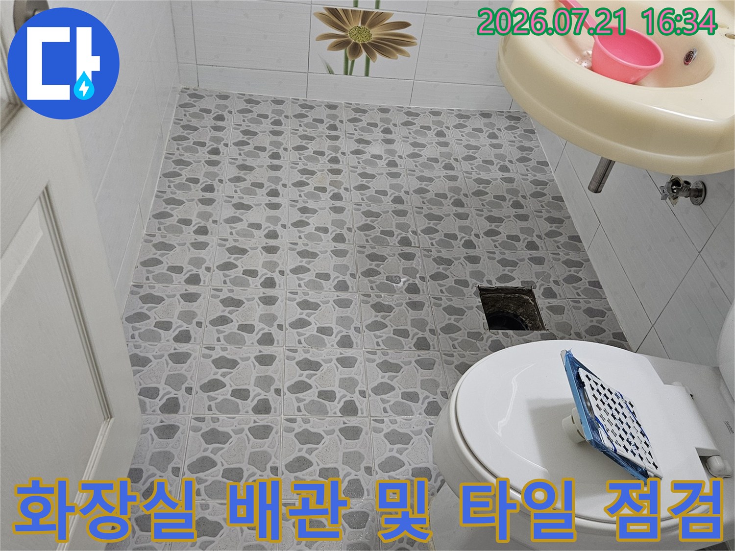 화장실 타일 벽면과 세면대 하부 배관 구조가 보이는 점검 현장 사진