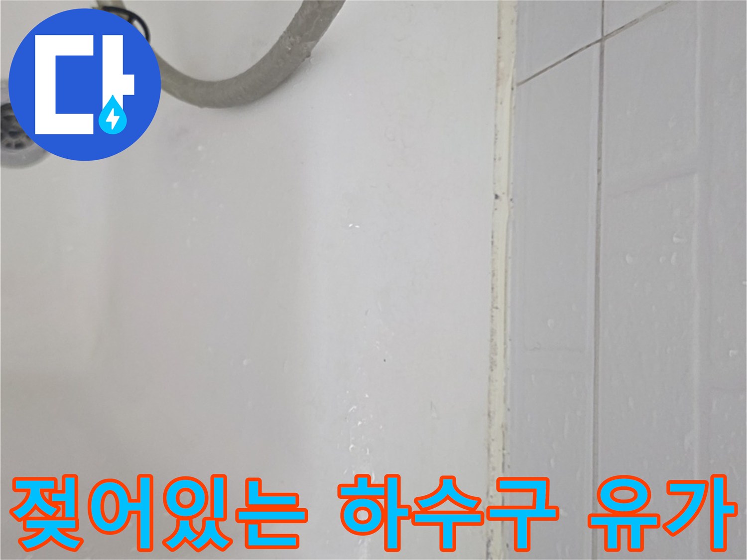 하수구 주변 타일이 물에 젖어 있는 모습